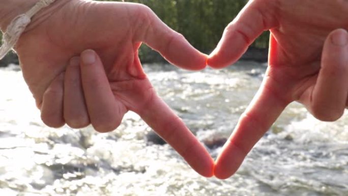 女人的手在山河之上创造心形