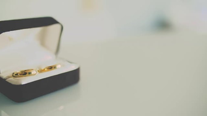 结婚戒指在桌子上滚动，触摸其他结婚戒指。