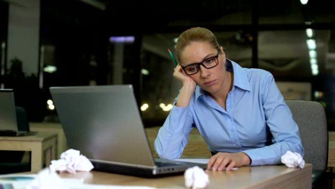 精疲力竭的女人缺乏商业想法，在办公室加班，倦怠