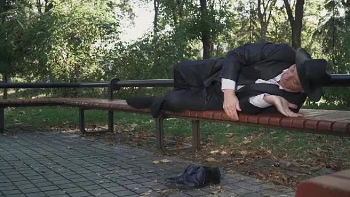 醉酒男子躺在公园的长凳上舒适