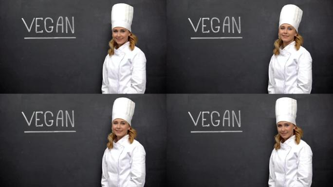微笑的首席厨师站在素食主义者的黑板上，饮食学