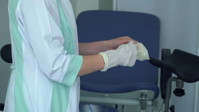 妇科医生在手术前将橡胶手套戴在手上