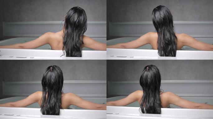 4k一个长发的黑人妇女的后背，她因努力工作而感到疲倦。她泡在浴缸里，休息了一下眼睛。