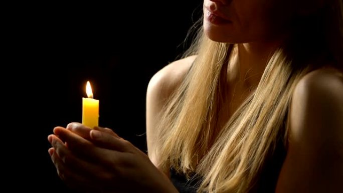 女性在祈祷后吹蜡烛，释放负面情绪