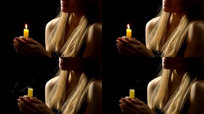女性在祈祷后吹蜡烛，释放负面情绪