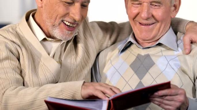 成熟的养老金领取者观看相册并微笑着，一起享受时光