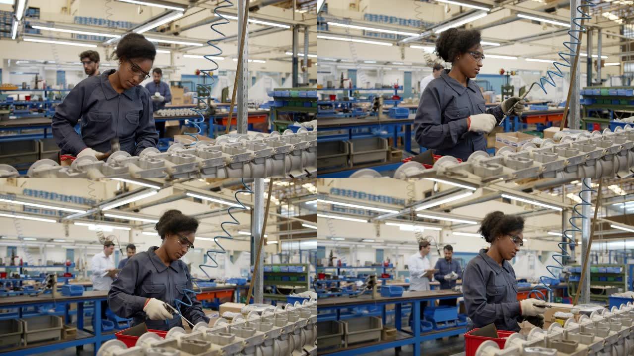 年轻的黑人妇女在生产线上的水泵工厂组装备件