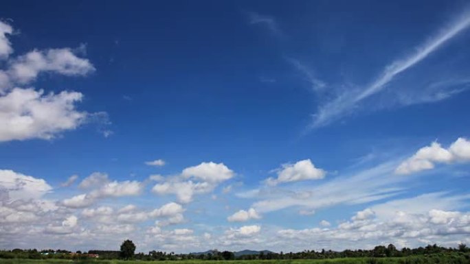 云彩的天空在牧场随风移动。