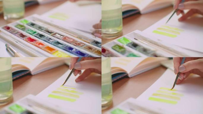 年轻女子用刷子和油漆做配色，为设计配色创建调色板。