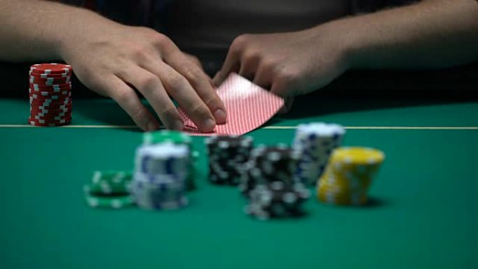 男子检查牌和加注，在扑克锦标赛中虚张声势，有机会获胜