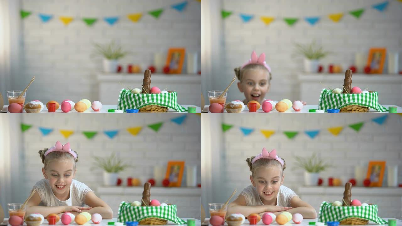 小女孩从桌子底下慢慢出现，欣赏五颜六色的复活节彩蛋