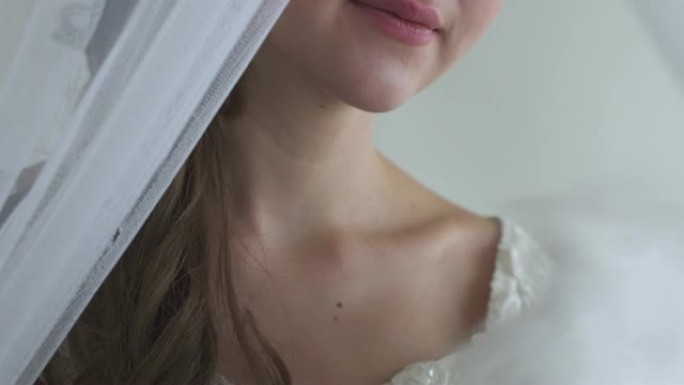 特写女人手扇子她的脸白色背景半脸真人系列白色羽毛扇。躲在面纱后面