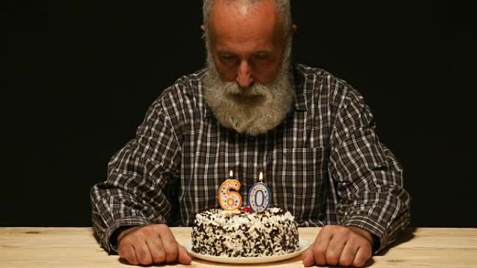 周年纪念蛋糕上有悲伤表情的老人