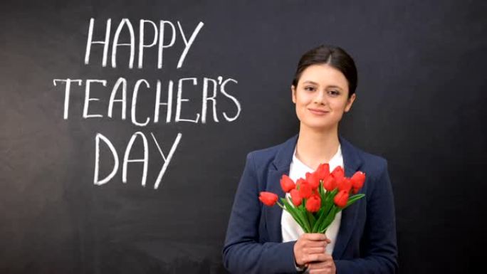 黑板上写着教师节快乐，郁金香站在旁边的微笑女士