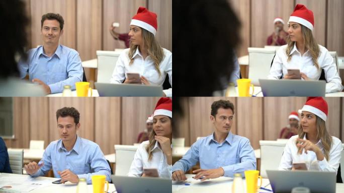 与圣诞老人帽子一起工作的商业同事