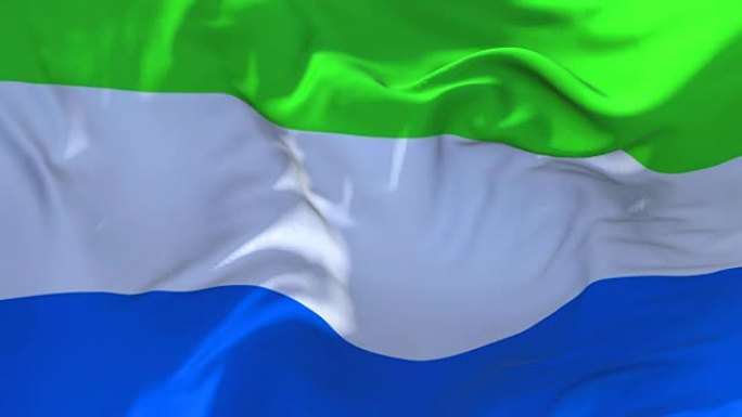 塞拉利昂国旗迎风飘扬的慢动作动画。4K逼真的织物纹理旗帜平稳吹在一个刮风的日子连续无缝循环背景。