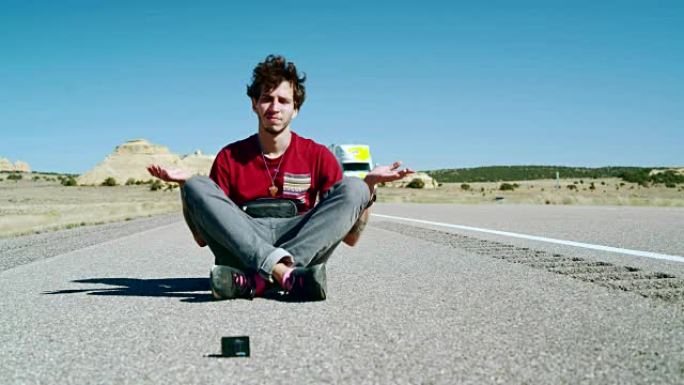 30岁的潮人vlogger坐在美国犹他州的高速公路上时，在动作摄影机前摆姿势。