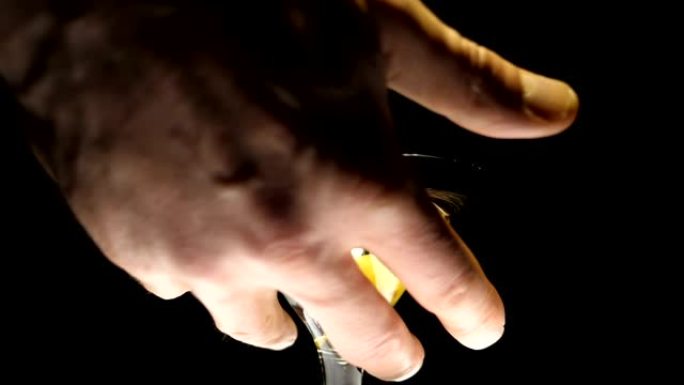 男性的手拿一个酒杯，里面装有马提尼酒 (白葡萄酒) 和橄榄