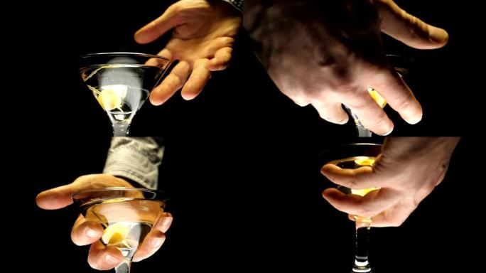 男性的手拿一个酒杯，里面装有马提尼酒 (白葡萄酒) 和橄榄
