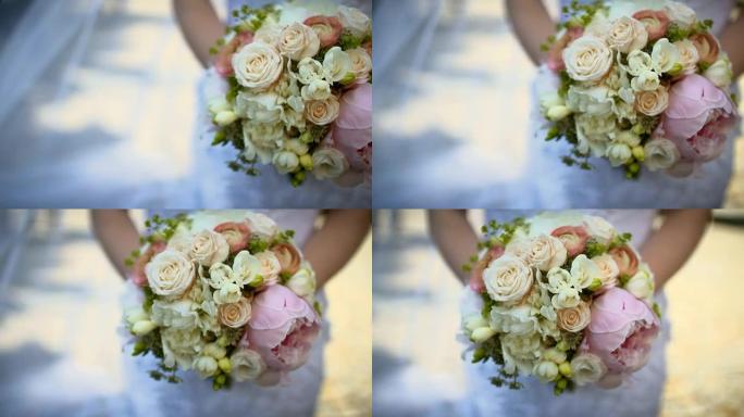 新娘在婚礼上捧着美丽的玫瑰花束。
