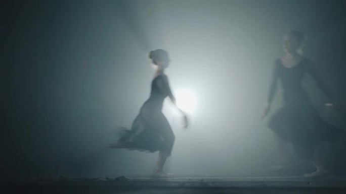两名年轻漂亮的女芭蕾舞女演员跑起来跳到不同的一边