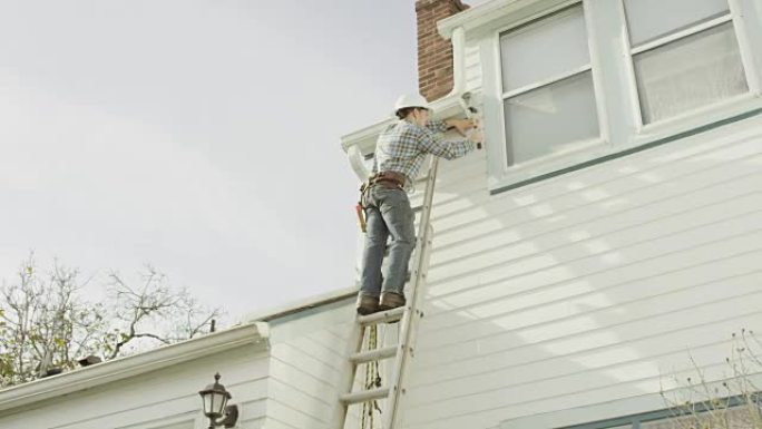 成年男性建筑工人在住宅上修理