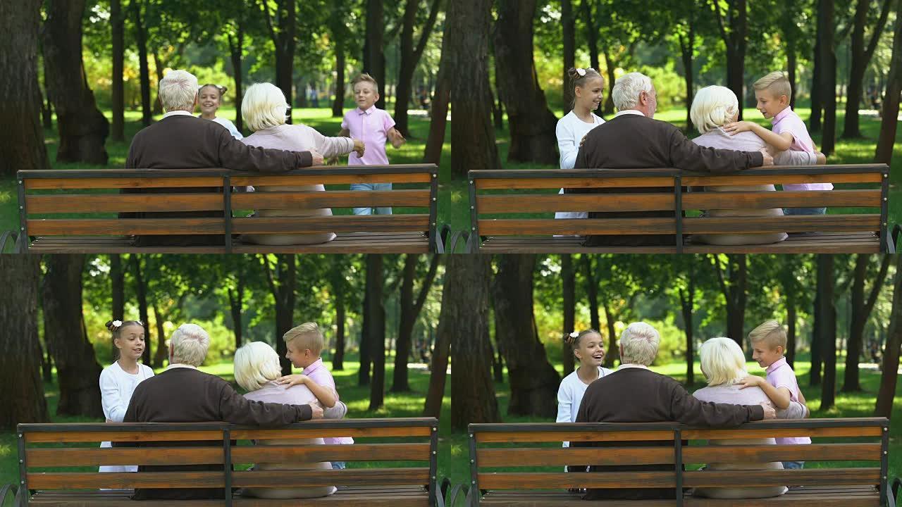 可爱的兄弟姐妹奔向坐在公园长椅上的祖父母，家庭