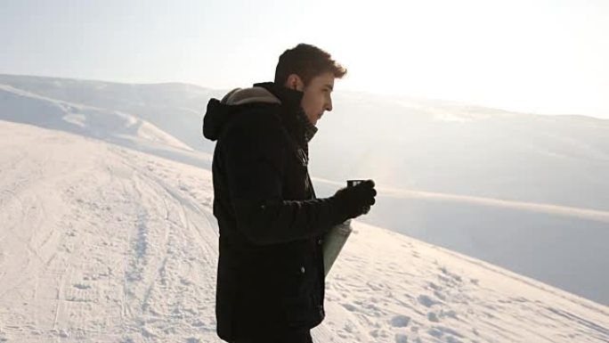 Man pours tea from a thermos winter