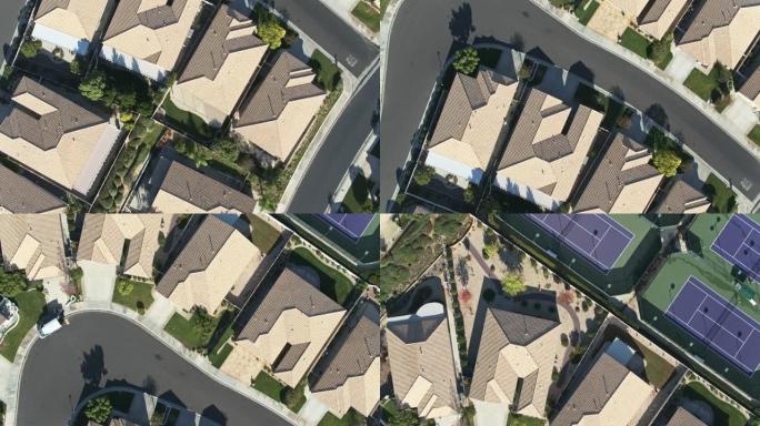 自上而下的无人机飞越郊区房屋和网球场