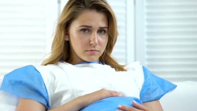 担心期望在医院病床上抚摸腹部的妇女，怀孕并发症