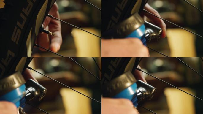 一名白人男性自行车技术员的手的特写镜头从山地自行车轮胎气门嘴上拧下盖子，并使用自行车泵将空气泵入轮胎