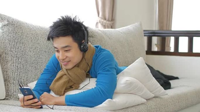 男人喜欢在家里放松时间听音乐和触摸智能手机，生活方式和放松概念，从右到左移动