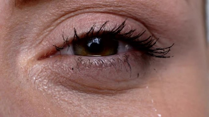 哭泣的女性眼睛宏观，绝望的感觉，医疗滴剂以获得更好的视力