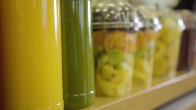 商店货架上的一排新鲜果汁和五颜六色的干果特写。照相机沿着杂货店的货物移动。健康食品，维生素，零售店。