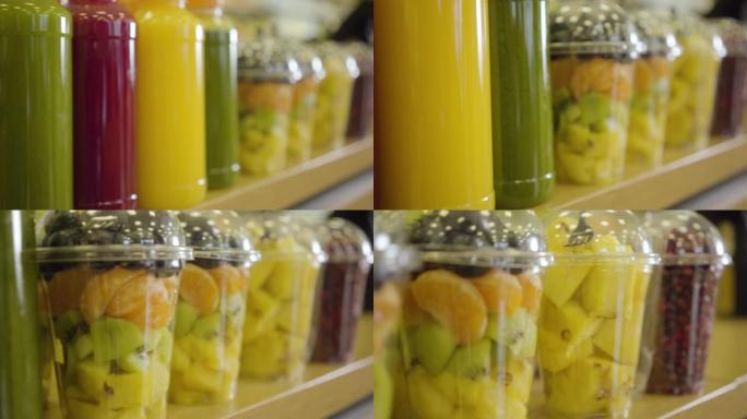 商店货架上的一排新鲜果汁和五颜六色的干果特写。照相机沿着杂货店的货物移动。健康食品，维生素，零售店。