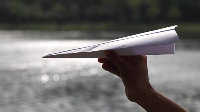 手中的折纸飞机和水池中的水