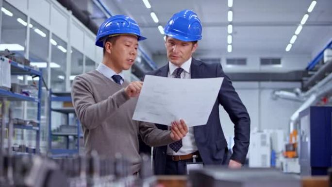 DS亚洲男工程师持有计划并与工厂所有者交谈