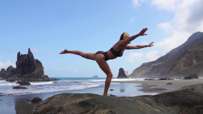 站在石头上的一条腿上做瑜伽平衡的女孩。安心。健康的生活方式。平衡与和谐，和平与平稳的动作
