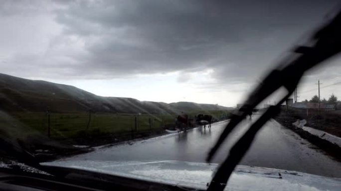 中国新疆雨天在山路上行驶的汽车。