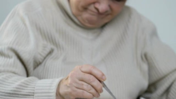 老年妇女厌恶地吃不可口的粥，扔勺子，疗养院