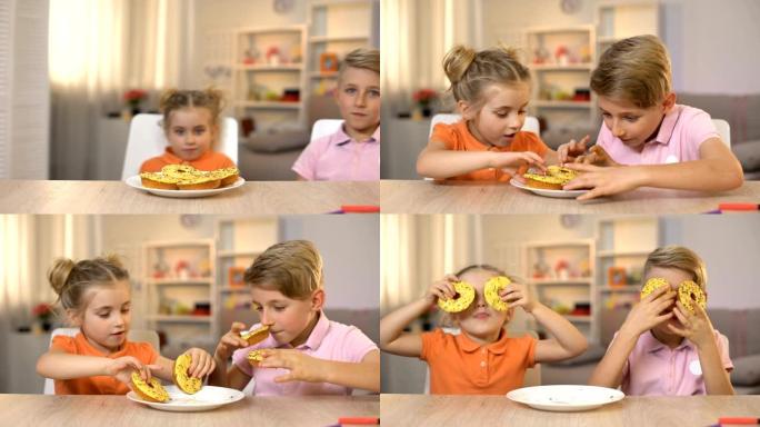 女孩和男孩在眼前拿着黄色的甜甜圈，玩得开心，不健康的零食