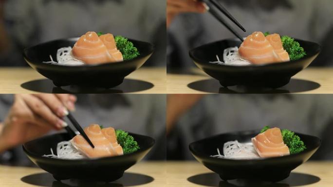 4K: 关闭筷子拿起三文鱼生鱼片日本食品