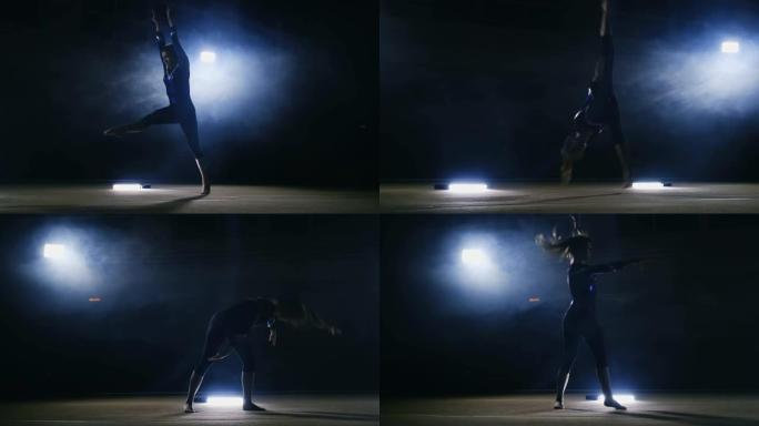 一个女孩在烟雾中的黑暗背景上表演跳跃体操