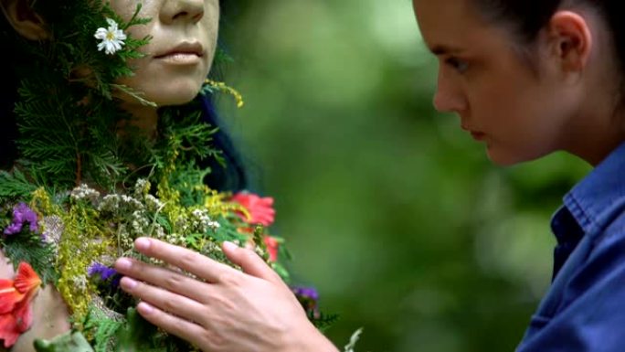 女人在森林中欣赏与大自然相连的绿叶和花朵