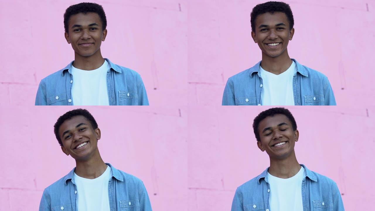 开朗的非裔美国男性少年在镜头前微笑，情绪积极