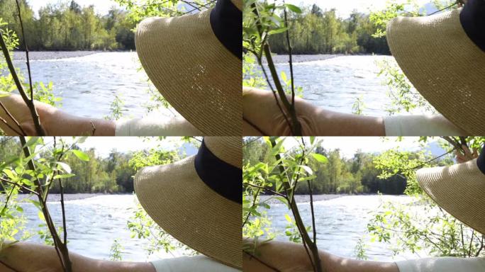 特写镜头，女人推回树枝露出河