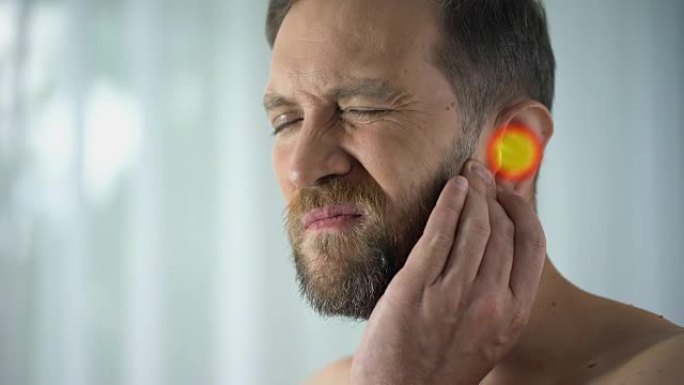 男人患有耳痛，中耳炎，听力问题，斑点表示疼痛，特写