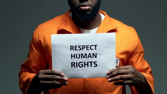 在美国黑人囚犯手中的纸板上写着“尊重人权”