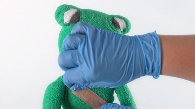 SLO MO LD医生在毛绒青蛙玩具上绑上绷带