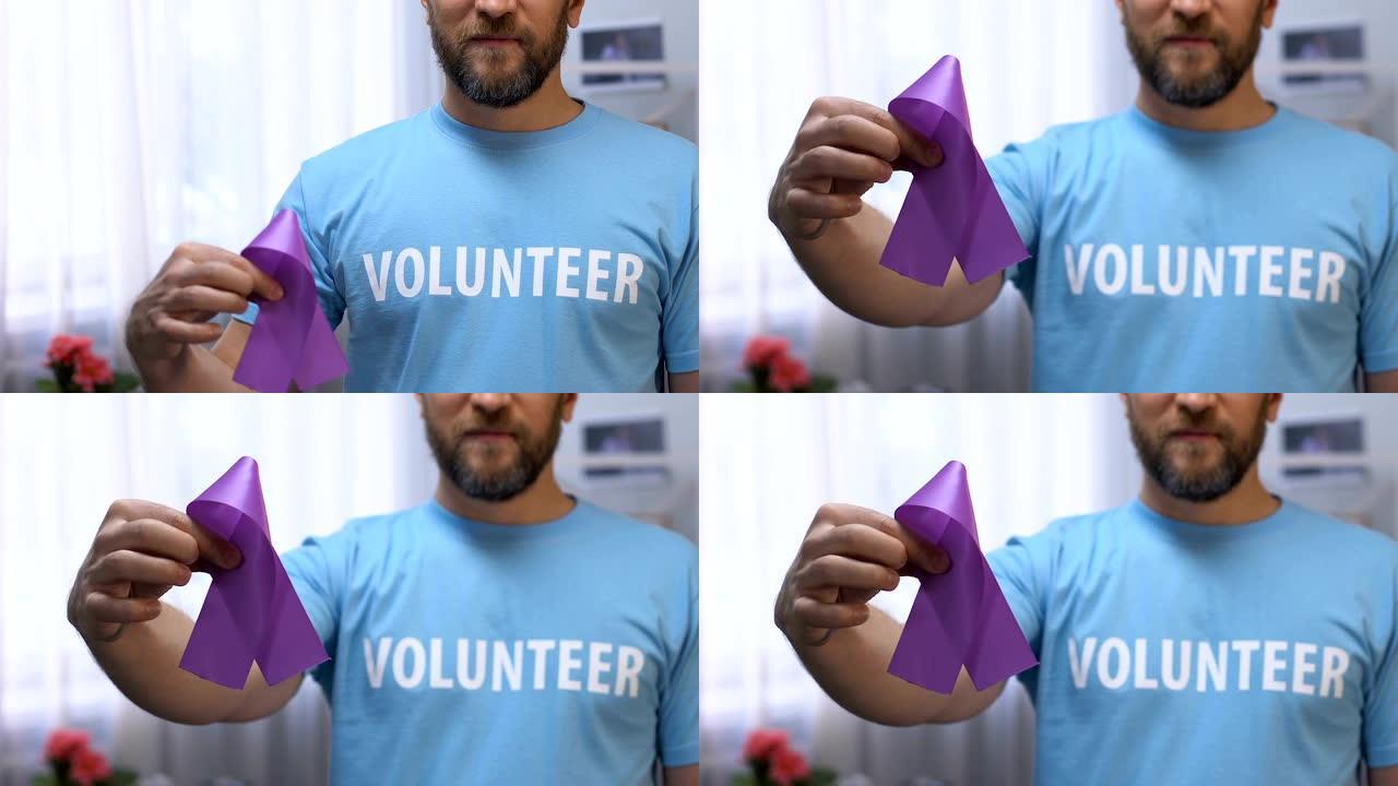 男性志愿者手拿紫丝带，对癫痫和胰腺癌有认识